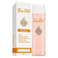 Image d'un produit de soin Bio-Oil de 200 ml, affichée à côté de son emballage. La bouteille contient une huile rosée et est étiquetée « Bio-Oil », tandis que l'emballage répertorie les avantages tels que le traitement des cicatrices, des vergetures, un teint inégal, le vieillissement cutané et la peau déshydratée.