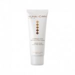 Un tube blanc de Nuhanciam Paris Gentle Scrub Instant Skin Radiance, avec un motif de losanges dorés, bronze et marron. Le texte sur le tube comprend les détails du produit et les instructions d'utilisation en anglais et en français.
