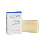 Image d'un emballage blanc et bleu de savon ultra riche Château Rouge Paris à côté d'un pain de savon beige non emballé. L'emballage du savon indique qu'il s'enrichit en huile d'amande douce, idéale pour les peaux sèches, d'un poids net de 150g.