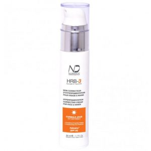 Un flacon blanc de crème correctrice d'hyperpigmentation ND (Nuance) HRB-3 pour le visage et les mains. Le flacon est doté d'un distributeur à pompe et d'une étiquette orange détaillant « Formule Jour » avec SPF 30. Le produit est de 50 ml ou 1,7 fl oz.