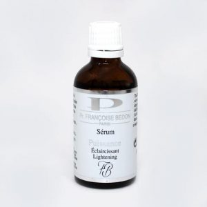 Un petit flacon marron foncé avec un bouchon à vis blanc étiqueté « Pr. Françoise Bedon Paris Sérum Puissance Éclaircissant Éclaircissant ». La bouteille porte une marque blanche et argentée avec une légère lettre « P » en arrière-plan. L'étiquette comprend du texte français.