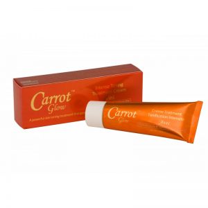 Un tube orange de Crème Soin Tonique Intense Carrot Glow est placé à côté de sa boîte assortie. La boîte est également orange avec le nom et la description du produit en texte blanc et doré. La crème est conçue pour un traitement tonifiant puissant pour la peau.