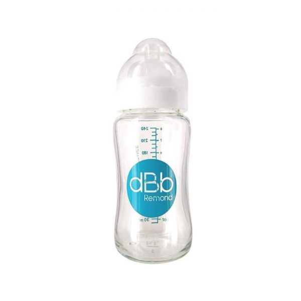 Un biberon transparent avec un bouchon blanc et des mesures bleues marquées sur le côté, indiquant le volume en millilitres. La bouteille porte un logo circulaire bleu avec le texte « dBb Remond » écrit dessus. La bouteille a une forme courbée et ergonomique pour une manipulation facile.