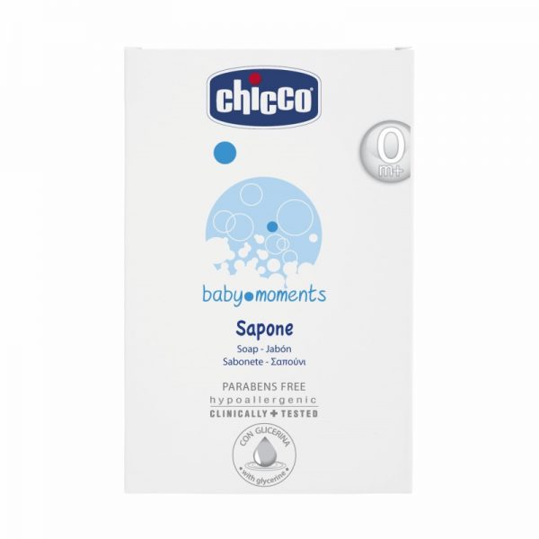 Un emballage blanc de savon Chicco Baby Moments est présenté. Le texte avant souligne qu'il convient aux nouveau-nés, qu'il est hypoallergénique, testé cliniquement et sans paraben. L'emballage indique également que le savon contient de la glycérine et affiche du texte en plusieurs langues.