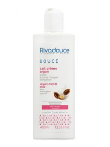 Une bouteille blanche de lotion pour le corps Rivadouce Douce Lait Crème Argan à l'huile d'argan, adaptée aux peaux sèches. La bouteille comporte un texte bleu, rose et noir, détaillant son lait crème à l'huile d'argan biologique. Le flacon contient 400 ml (13,53 fl oz) de produit.