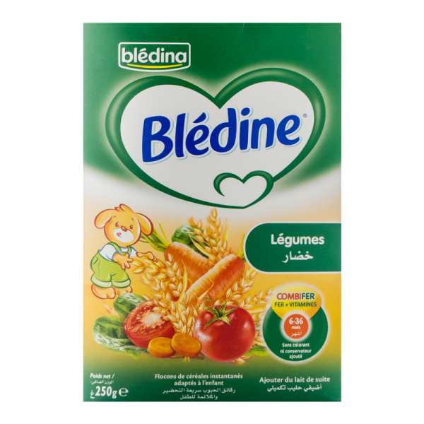 Boite de flocons de céréales Blédina Blédine. L'emballage est vert avec un logo en forme de cœur blanc. Une illustration montre des légumes comme des carottes, des tomates et des pois. Un lapin de dessin animé est présent. Le texte indique que le produit convient aux nourrissons de 6 à 36 mois et est riche en fer et en vitamines.