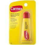 Un tube jaune et rouge de Baume à Lèvres Carmex Classic dans son emballage. L’emballage est jaune avec un texte blanc et noir détaillant les propriétés apaisantes et hydratantes du produit et indique qu’il procure un soulagement durable aux lèvres sèches et gercées. Le tube contient 10 grammes.