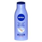 Un flacon de lotion pour le corps Nivea Smooth Sensation avec un bouchon et une étiquette bleus. L'étiquette comprend un logo Nivea circulaire bleu, un texte le décrivant comme une lotion « soin hydratant » pour les peaux normales à sèches avec du beurre de karité et une image d'une éclaboussure de lotion aux noix de karité.