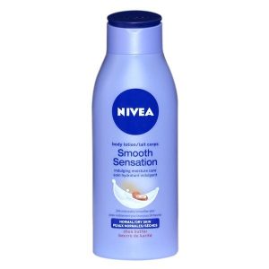 Un flacon de lotion pour le corps Nivea Smooth Sensation avec un bouchon et une étiquette bleus. L'étiquette comprend un logo Nivea circulaire bleu, un texte le décrivant comme une lotion « soin hydratant » pour les peaux normales à sèches avec du beurre de karité et une image d'une éclaboussure de lotion aux noix de karité.