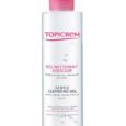 Un flacon transparent de 200 ml de Gel Nettoyant Doux Topicrem avec un bouchon rose, étiqueté en français et en anglais. Le produit prétend nettoyer et démaquiller en douceur, adapté aux peaux sensibles et sèches. L'étiquette est blanche avec du texte et des accents roses.
