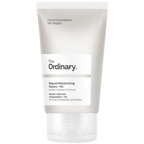 Un tube blanc et gris de The Ordinary Natural Moisturising Factors + HA, une formule d'hydratation de surface. Le tube est doté d'un bouchon à vis et comporte un texte en noir et gris, soulignant qu'il s'agit d'une formulation clinique intègre.