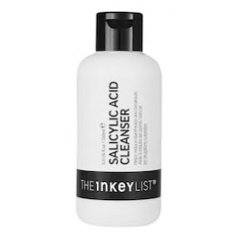 Une bouteille blanche avec un bouchon noir étiqueté « SALICYLIC ACID CLEANSER » par The Inkey List. L'étiquette comporte un texte noir en gras sur fond blanc avec une bande noire près du bas affichant le nom de la marque.