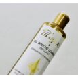 Gros plan d'une bouteille de gel douche exfoliant « Maya » au bouchon doré sur un fond blanc uni. L'étiquette indique « Gel Douche Gommant Exfoliant » et présente un motif de gouttelettes dorées.