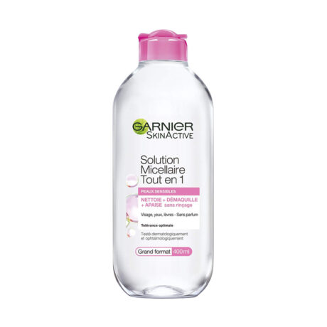 Un flacon transparent de Garnier SkinActive Solution Micellaire Tout en 1 avec un bouchon rose. L'étiquette indique qu'il est destiné aux peaux sensibles et qu'il nettoie, démaquille et apaise sans rinçage. Le format du flacon est de 400 ml et le texte est en français.