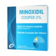 Une boîte de Minoxidil Cooper 2% est présentée. L'emballage est principalement bleu et blanc avec des motifs de lignes qui se chevauchent. Le texte est en français, soulignant qu'il est utilisé en cas de chute de cheveux modérée et favorise la croissance des cheveux. Il contient trois flacons de 60 ml à usage topique.