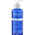 Un flacon bleu de lotion antipelliculaire capillaire Uriage DS avec un distributeur à pompe blanc. L'étiquette comprend un texte en français et en anglais détaillant sa fonction pour éliminer les squames, purifier et apaiser les démangeaisons. Le produit est sans parfum et convient aux cuirs chevelus sensibles.