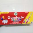 Une boîte de dentifrice rouge Gumforte Junior Dentifrice contenant 50 g de dentifrice aromatisé à la fraise. La boîte présente un personnage de dent souriant avec des ballons, un logo vert « BIO » et un texte soulignant les bienfaits du produit pour des dents fortes et saines. Une étiquette « Gratuit » est également affichée.