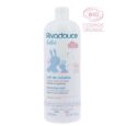 Un flacon blanc de Lait Démaquillant Rivadouce Bébé avec une étiquette bleue comportant des illustrations d'un parent et d'un bébé lapin. Le produit est marqué comme biologique avec la certification « Cosmos Organic », contient 1 000 ml et est décrit comme adapté au visage, au corps et aux couches.