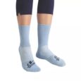 Une personne portant des chaussettes bleu clair. Les chaussettes ont une zone des orteils et du talon bleu plus foncé avec un logo et le mot « Jinning » écrit sur le dessus de chaque chaussette, près des orteils. Les mollets de la personne sont partiellement visibles et elle porte un pantalon sombre.