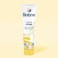 un tube de crème pour le change biolane est affiché sur un fond jaune clair. le tube comporte le logo biolane et un texte en français, indiquant qu'il répare et protège la peau. différents logos de certification sont également visibles au bas du tube.
