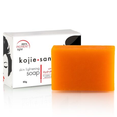 Une barre orange de KOJIE SAN Savon Anti taches Unifiant 65g est placée devant sa boîte d'emballage blanche, qui comporte un texte en noir et rouge et l'image d'un visage de femme. Le savon pèse 65 grammes, mentionne HydroMoist pour ses effets hydratants supplémentaires et est populaire à Dakar, au Sénégal.