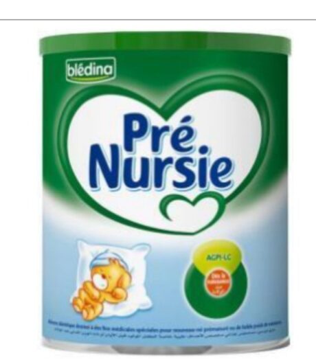 une boîte verte et blanche de préparation en poudre pour nourrissons blédina pré nursie. la boîte présente le graphisme d'un ours endormi avec une tétine sur un oreiller. une forme de cœur proéminente entoure le logo de la marque. situé sur un fond blanc.