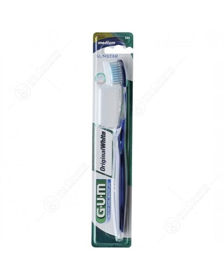 une brosse à dents gum original white medium emballée avec un manche bleu et des poils blancs. l'emballage est vert et blanc avec le nom de la marque « sunstar » visible.