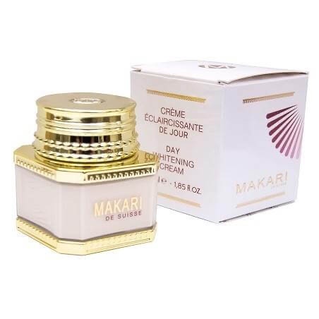 un pot de crème éclaircissante de jour makari de suisse avec un couvercle doré est exposé à côté de son emballage en boîte blanche, qui présente des accents violets et dorés.