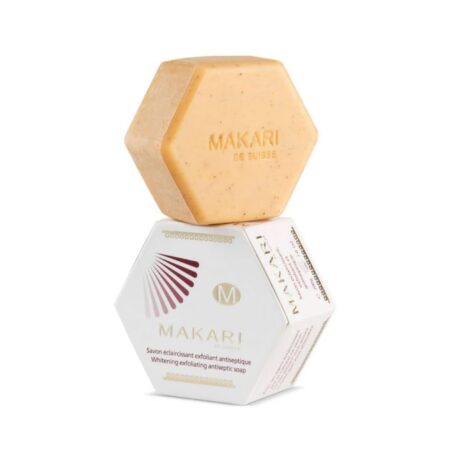 barre de savon hexagonale orange avec le nom de marque « makari de suisse » empilée sur sa boîte assortie. la boîte comprend un texte le décrivant comme un « savon exfoliant antiseptique blanchissant » avec un motif décoratif et un logo.