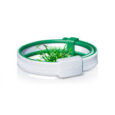 un bracelet blanc et vert encercle une petite parcelle d'herbe verte. le bracelet est doté d'un fermoir blanc et présente un design qui ressemble à une texture tissée.