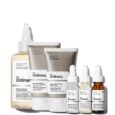 une collection de six produits de soins de la peau de the ordinary, comprenant un flacon de toner avec un bouchon pointu, deux tubes de nettoyant et d'hydratant et trois petits flacons compte gouttes.