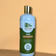 un flacon blanc au bouchon doré, étiqueté « bio nora gel de douche », repose sur une surface beige sur fond pêche. l'étiquette est verte et blanche, et la contenance du flacon est de 500 ml.