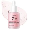 un flacon compte gouttes rose étiqueté "anua 70+ peach 70 niacin serum" est présenté devant un liquide rose translucide, avec un texte noir et rose clair détaillant les informations sur le produit.