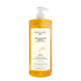 un flacon transparent de byphasse gel douche dermo micellaire argan body wash avec un distributeur à pompe blanc, rempli d'un liquide jaune orangé, présenté sur un fond blanc uni.