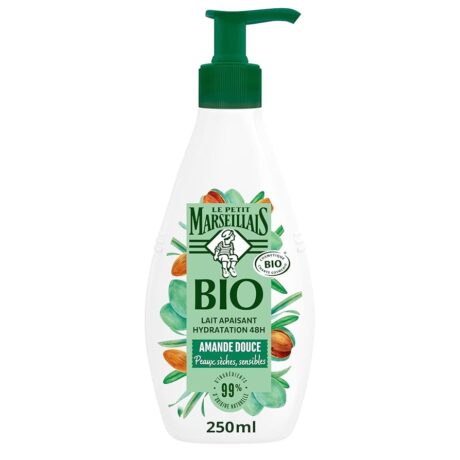 un flacon du petit marseillais bio lait apaisant avec une pompe verte, étiqueté "amande douce" pour les peaux sèches et sensibles. l'étiquette représente des amandes et des feuilles vertes. le flacon contient 250 ml.
